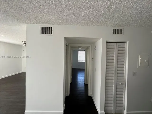 a view of a hallway with wooden floor and closet