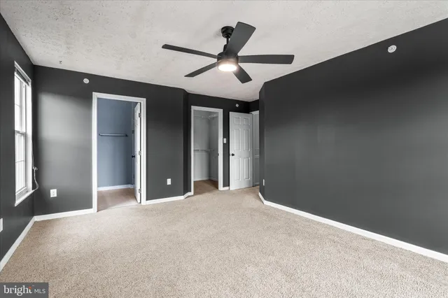a view of a livingroom with a ceiling fan and window