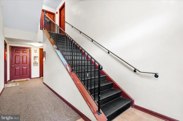 a view of staircase with lots of frames on wall and a window
