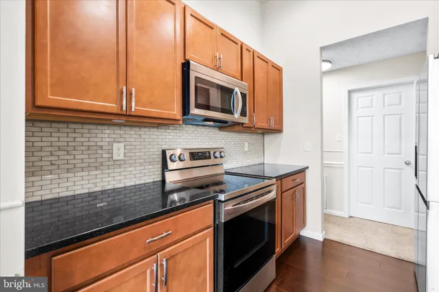 a kitchen with stainless steel appliances granite countertop a stove and a microwave