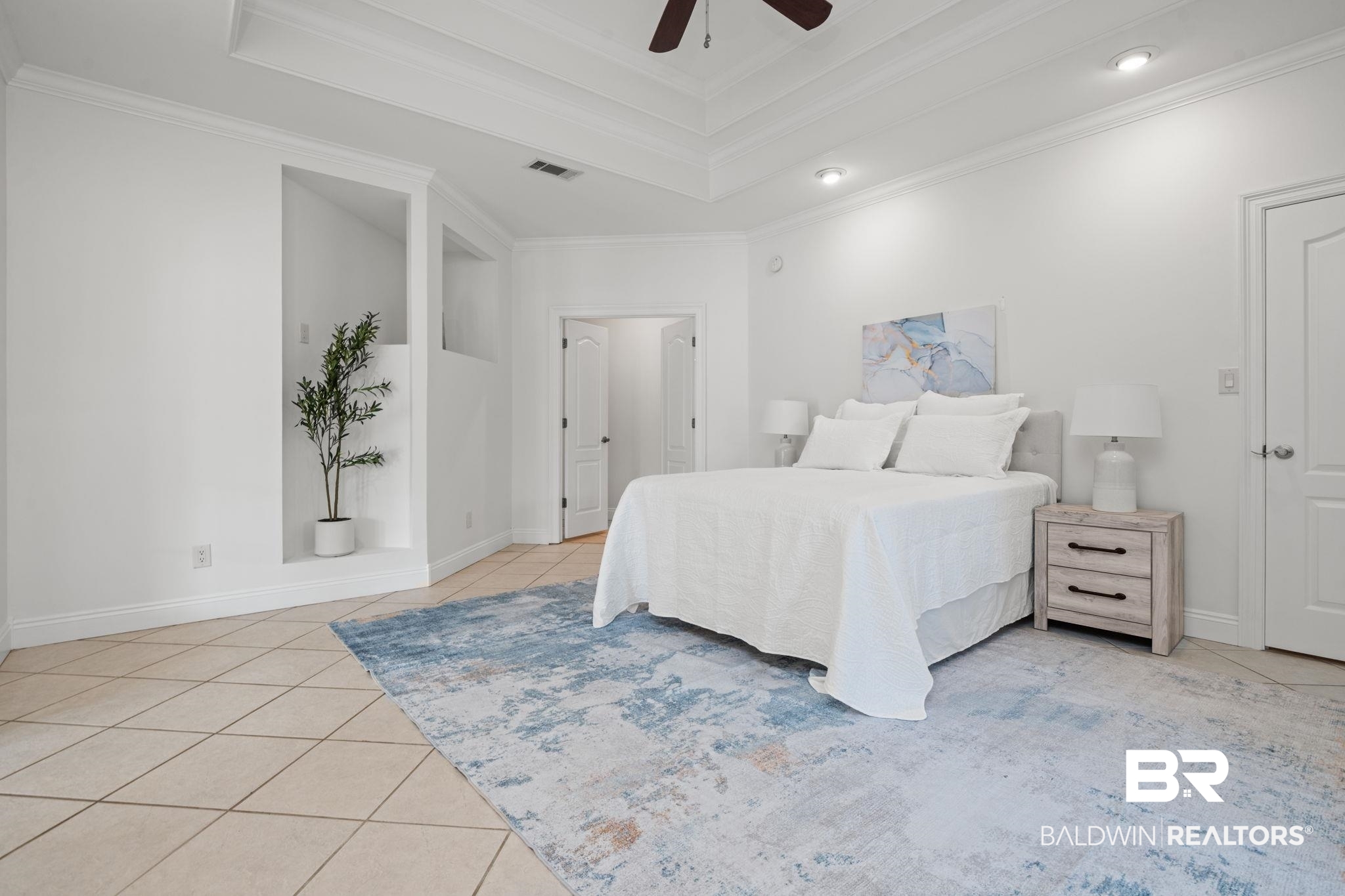 29634 St George Street Daphne, AL 36526 - Photo 24 of 47 Bedroom featuring light tile patterned floors, crown molding, a raised ceiling, and ceiling fan