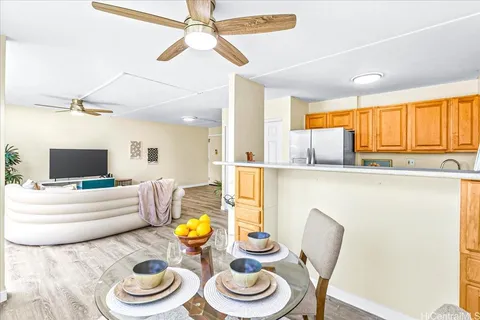 a living room with kitchen and a wooden floor