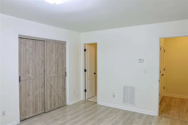 an empty room with windows and chandelier fan