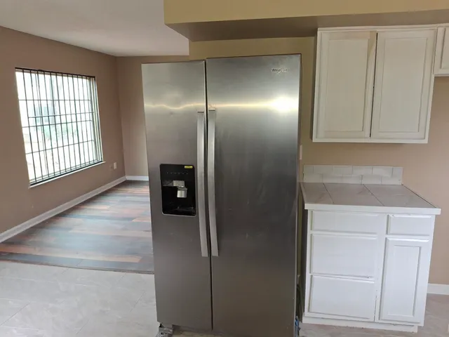 a view of an empty room with wooden floor and stairs