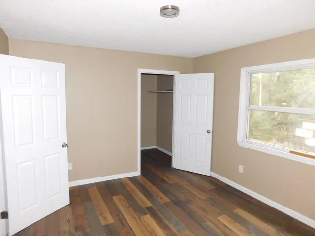 an empty room with wooden floor and entrance