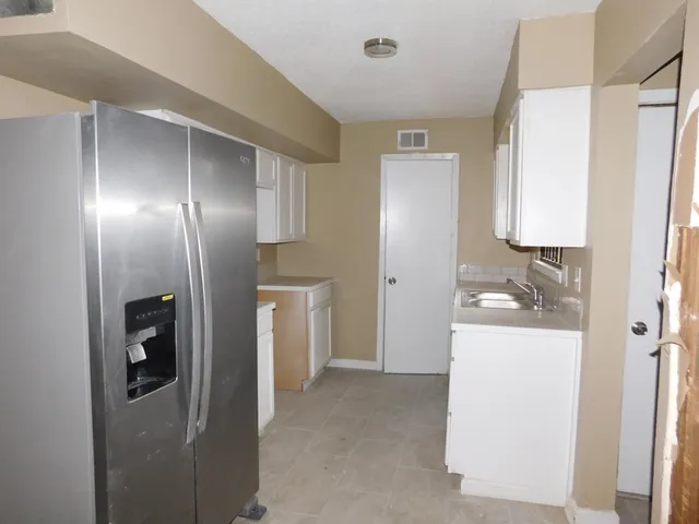 a view of hallway with shower and white walls