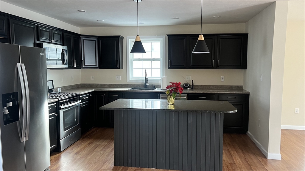 15 Gale Street, Unit 1 Lawrence, MA 01841 - Photo 4 of 25 a kitchen with stainless steel appliances granite countertop a sink refrigerator and microwave