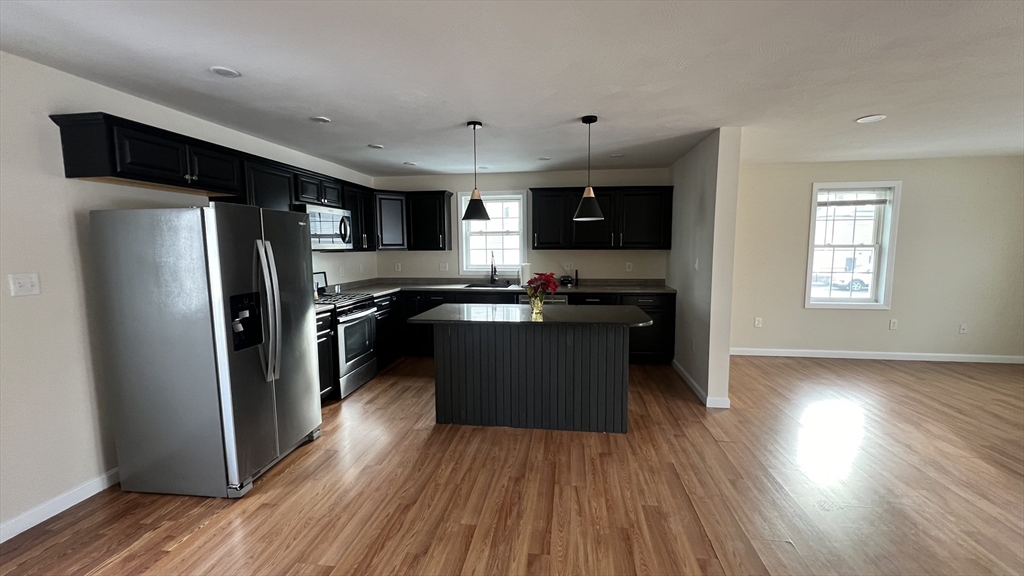 15 Gale Street, Unit 1 Lawrence, MA 01841 - Photo 5 of 25 a kitchen with stainless steel appliances a refrigerator and a stove top oven