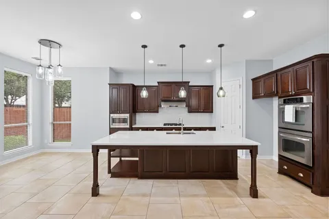 a large kitchen with a large counter top stainless steel appliances and cabinets