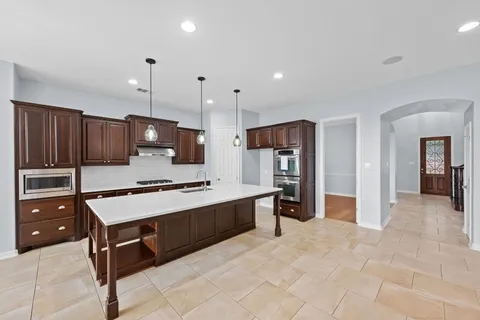a kitchen with stainless steel appliances a stove a refrigerator and a sink