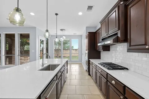 a kitchen with stainless steel appliances a sink a stove and a wooden floors