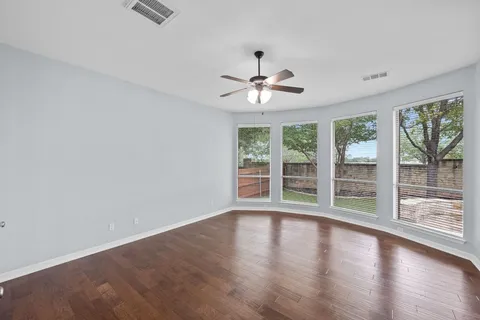 a view of wooden floor and a chandelier fan in a room