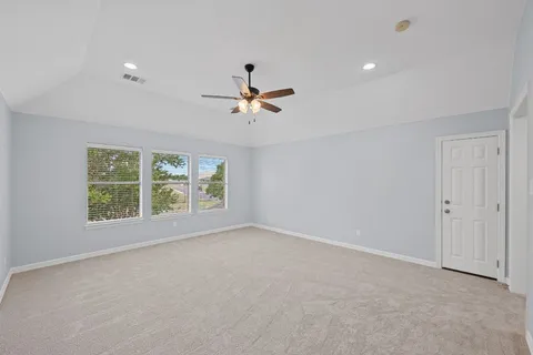 a view of a room with a ceiling fan and a window