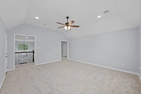 an empty room with windows and ceiling fan