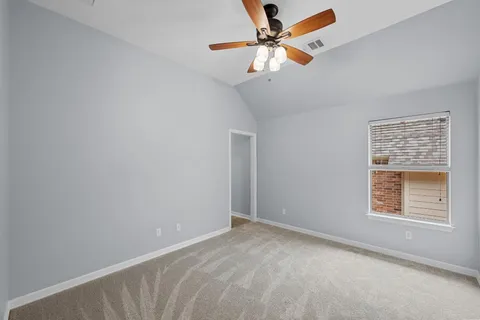 an empty room with a window and a fan