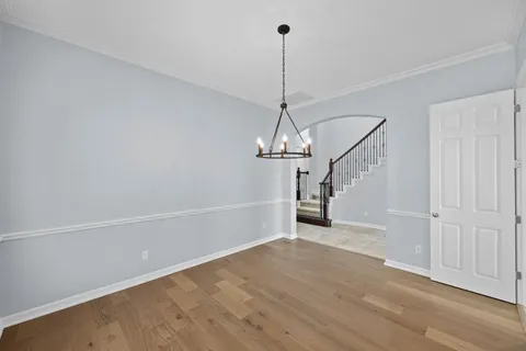 a view of empty room with wooden floor and ceiling fan