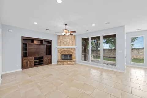 a view of an empty room with a fireplace and a flat screen tv