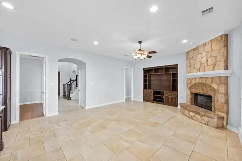 a view of a livingroom with a fireplace cabinet and windows