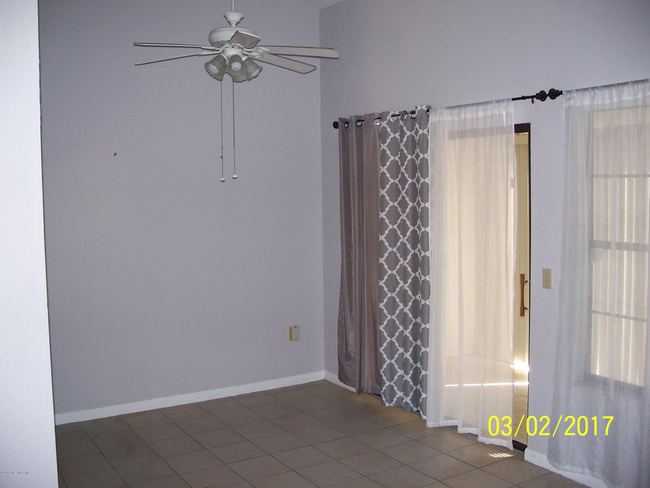 4429 Southwest 20th Lane Gainesville, FL 32607 - Photo 11 of 12 a view of a bathroom with a shower curtain and a window