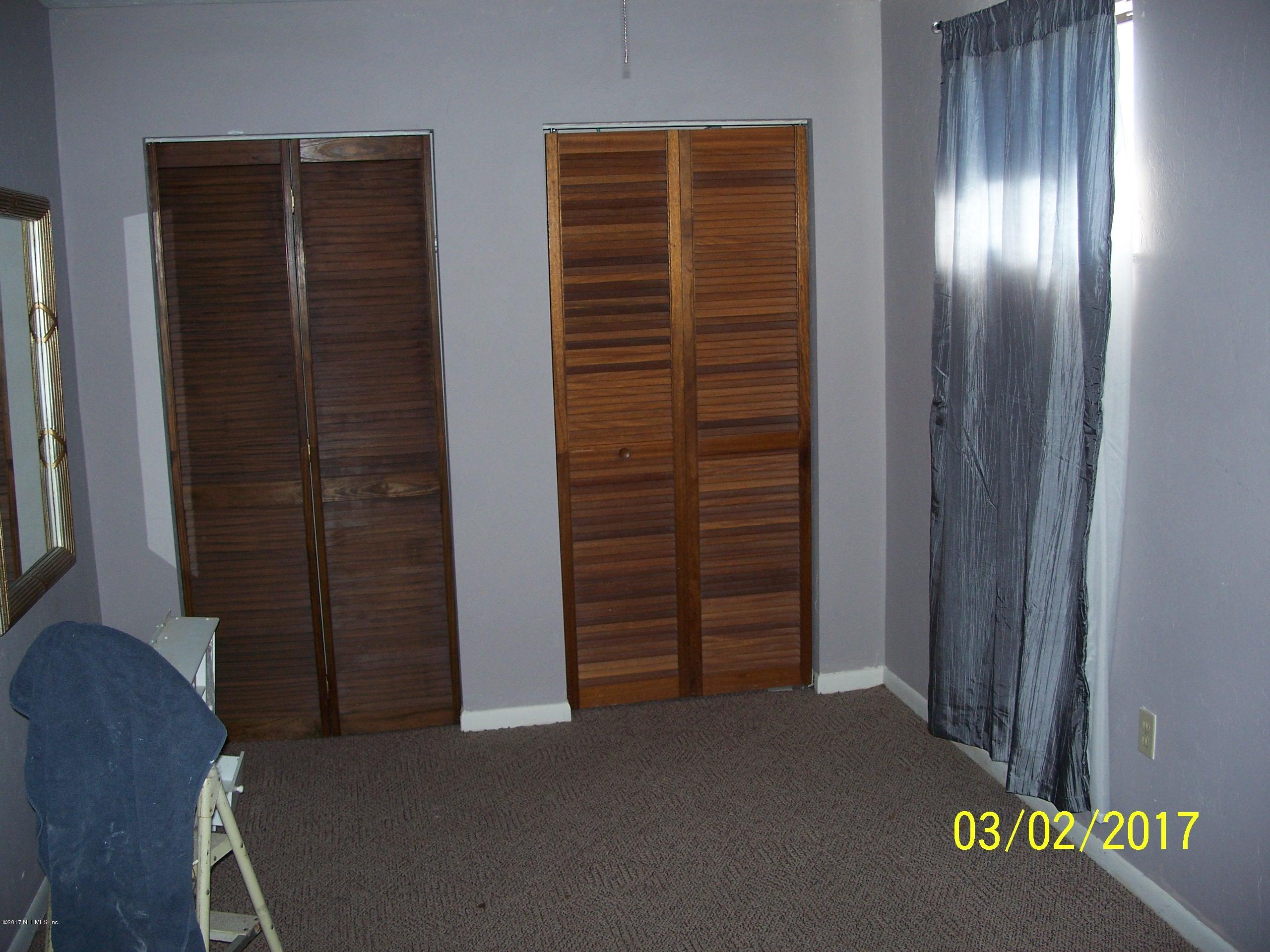 4429 Southwest 20th Lane Gainesville, FL 32607 - Photo 7 of 12 an empty room with windows wooden wall and closet