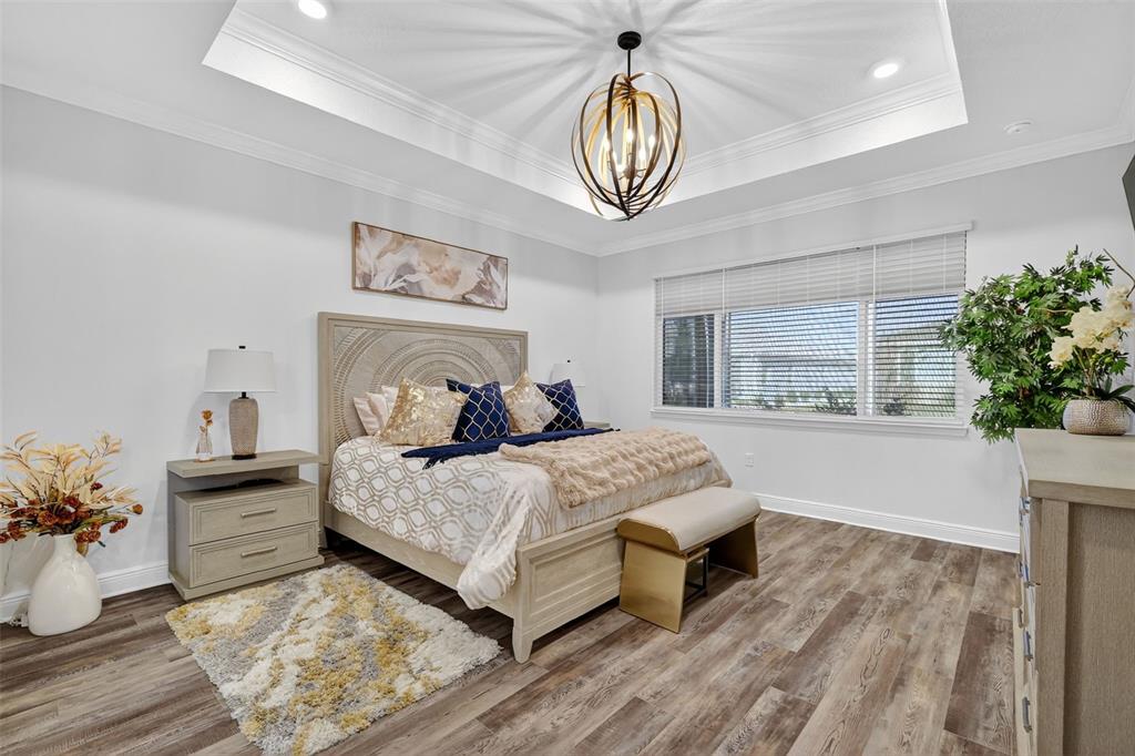 8433 Southwest 98th Terrace Road Ocala, FL 34481 - Photo 16 of 30 a bedroom with a large bed and a chandelier