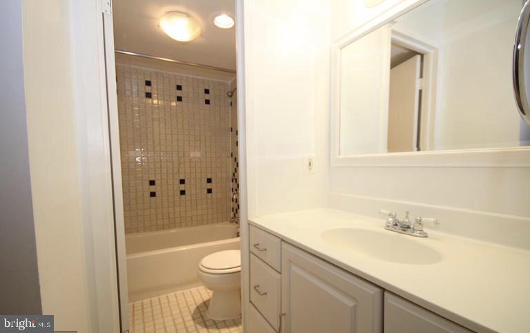 6800 Fleetwood Road, Unit 214 McLean, VA 22101 - Photo 12 of 22 a bathroom with a granite countertop sink toilet and shower