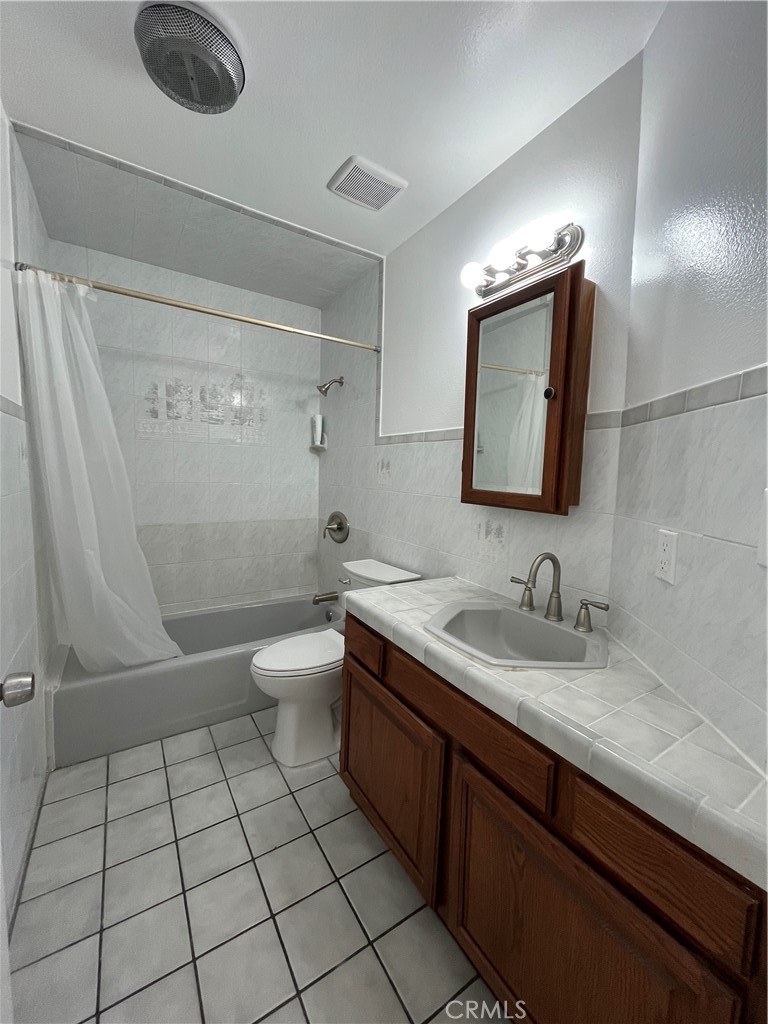 7522 Balcom Avenue Reseda, CA 91335 - Photo 11 of 22 a bathroom with a granite countertop sink a toilet a mirror and shower