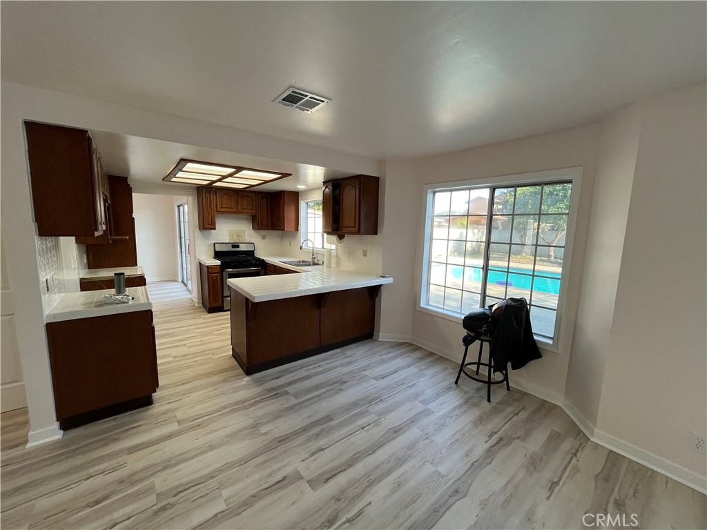 7522 Balcom Avenue Reseda, CA 91335 - Photo 9 of 22 a living room with stainless steel appliances kitchen island granite countertop furniture wooden floor and a window