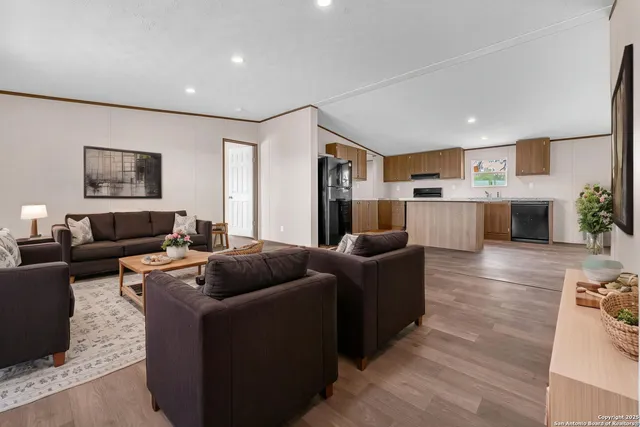 a living room with furniture and kitchen view