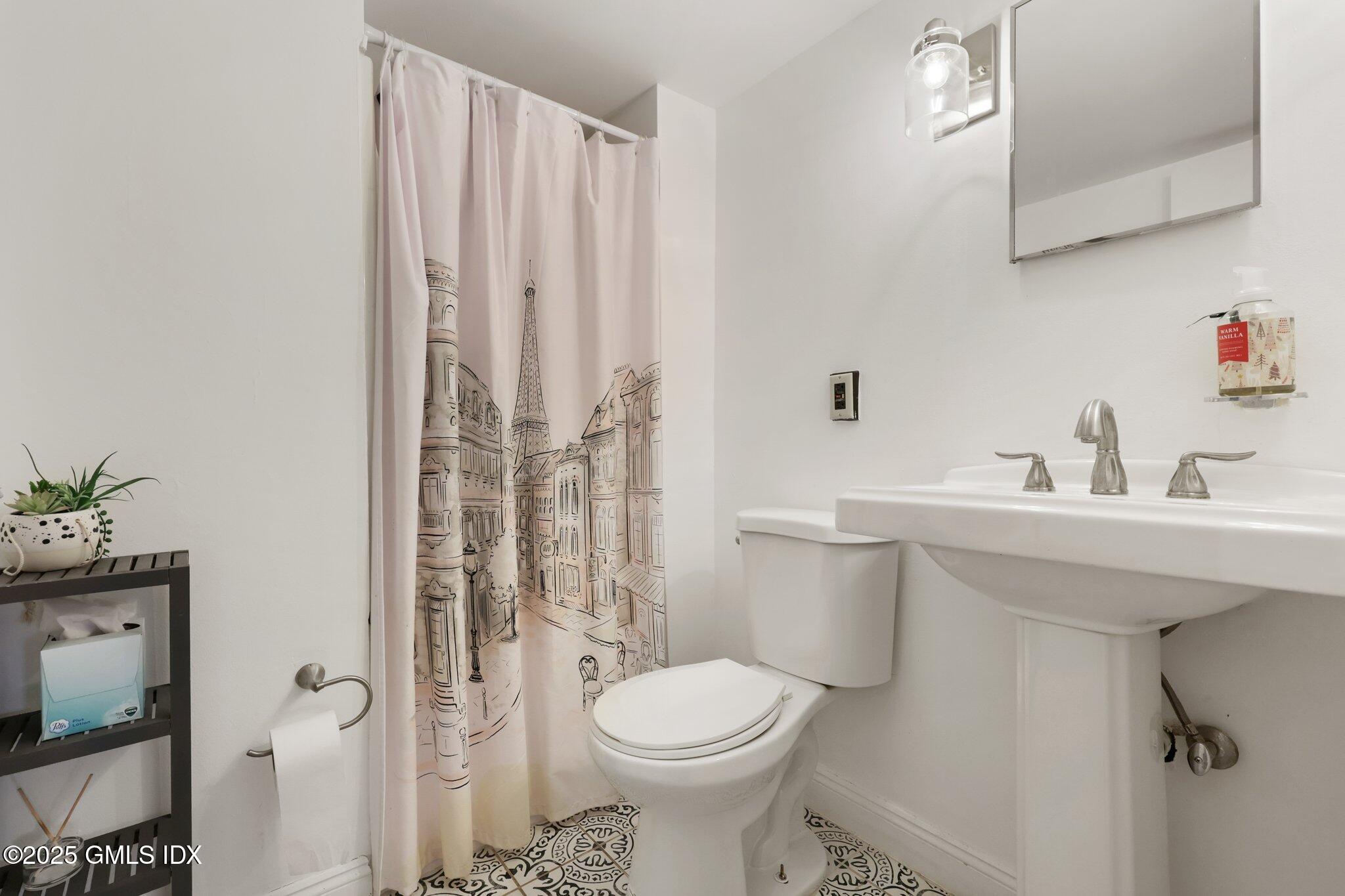 81 Hendrie Avenue Riverside, CT 06878 - Photo 30 of 35 a bathroom with a sink a toilet and shower curtain