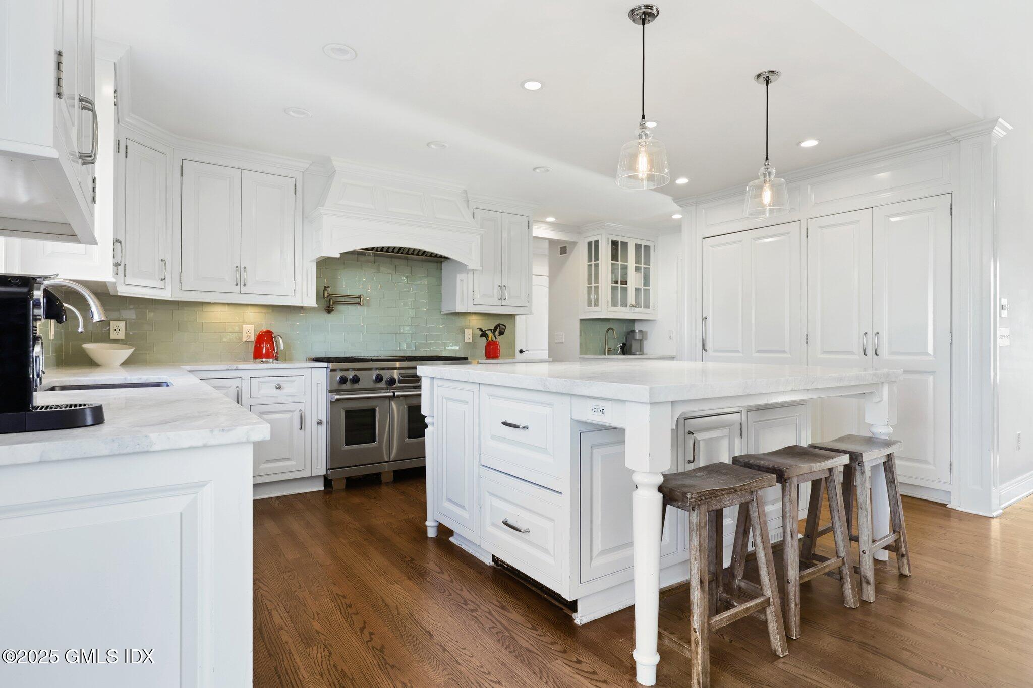 81 Hendrie Avenue Riverside, CT 06878 - Photo 5 of 35 a kitchen with stainless steel appliances granite countertop a white cabinets and stove top oven