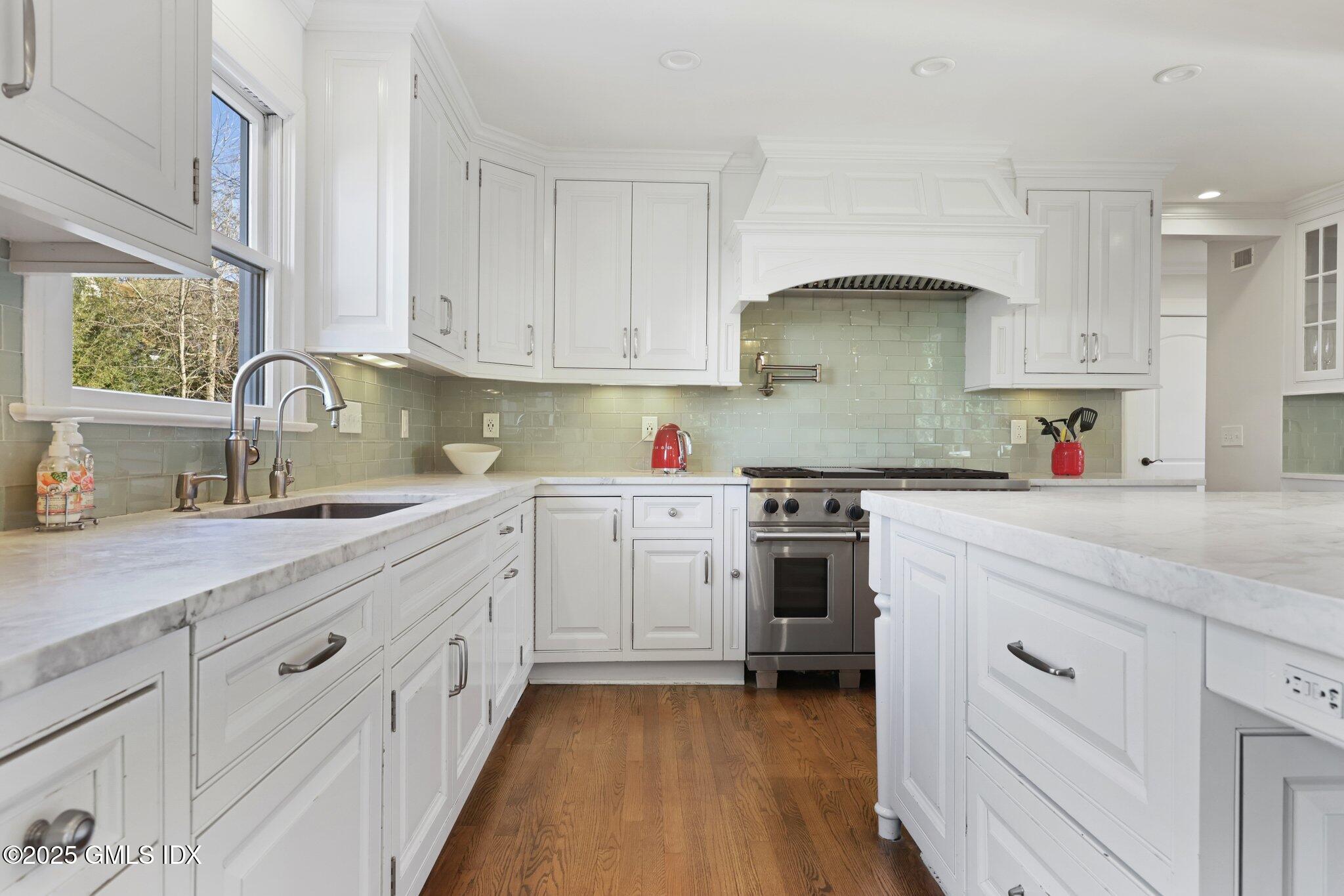 81 Hendrie Avenue Riverside, CT 06878 - Photo 6 of 35 a kitchen with white cabinets appliances and a sink