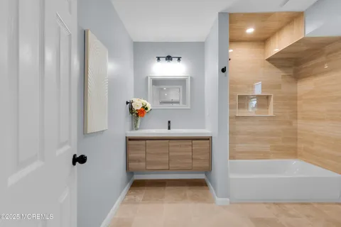 a bathroom with a sink a tub and a mirror