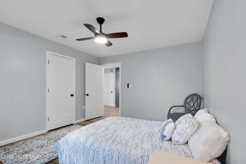 a bedroom with a bed and a ceiling fan