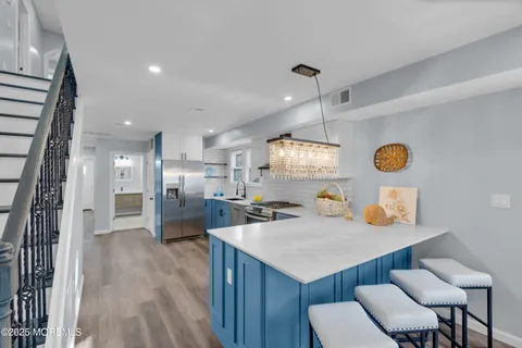 a kitchen with refrigerator and chairs