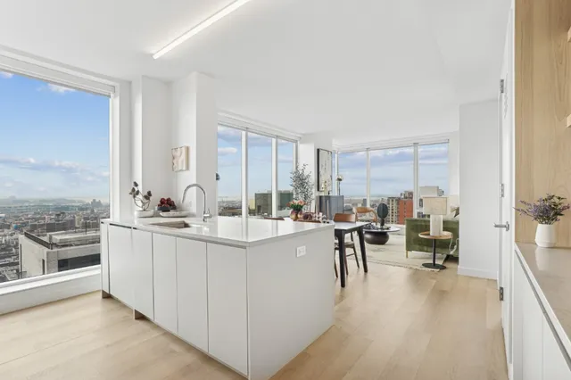 a view of a kitchen with kitchen island granite countertop a large counter top furniture and a view of living room