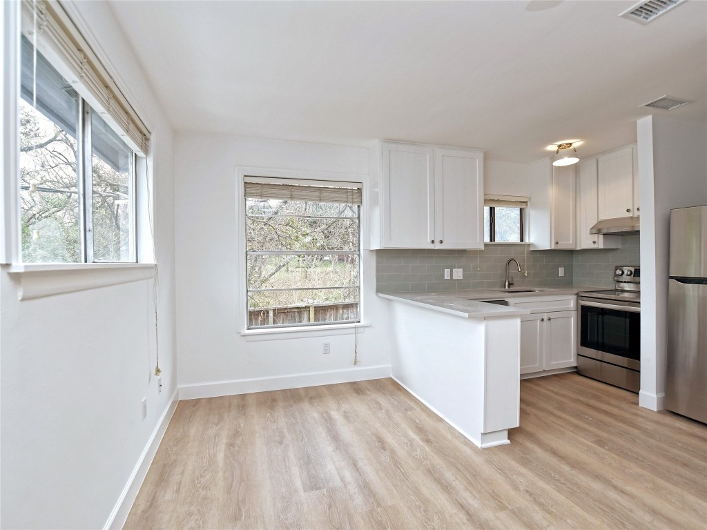 a kitchen with a white cabinets and window