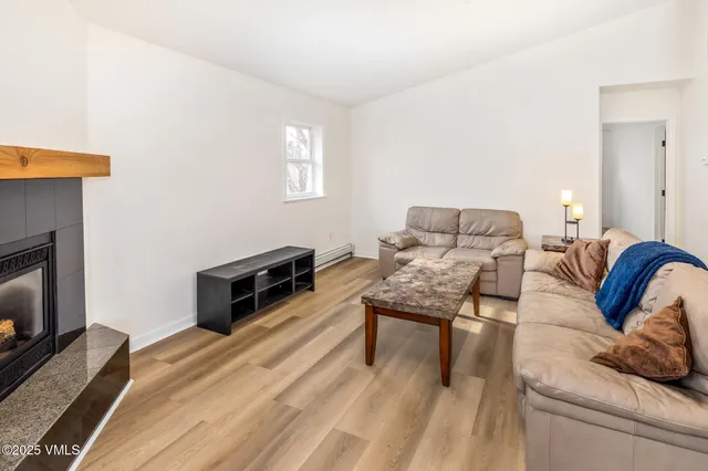 a living room with furniture a fireplace and a flat screen tv