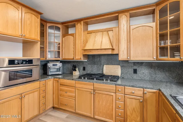 a kitchen with stainless steel appliances granite countertop a stove a sink and a microwave