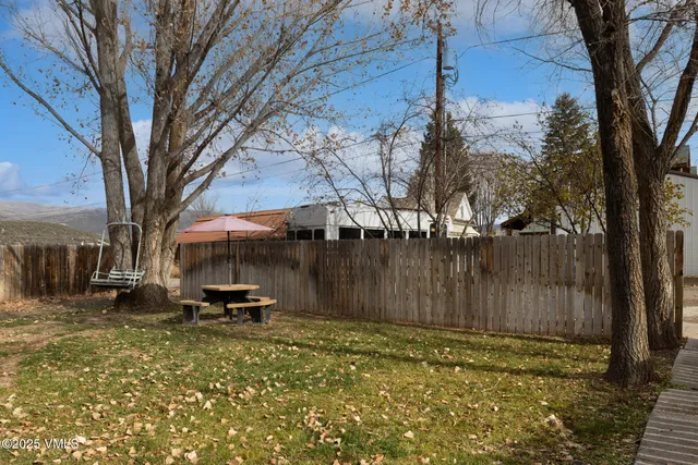 a backyard of a house with table and chairs