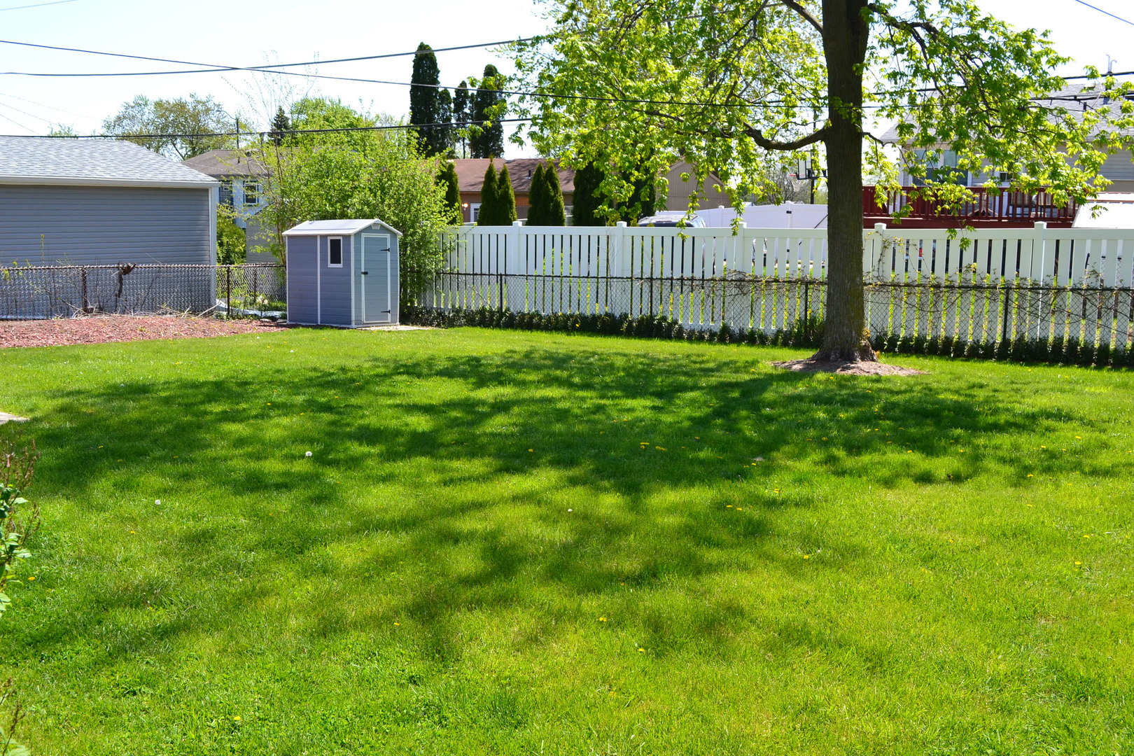 307 Karen Avenue Romeoville, IL 60446 - Photo 19 of 20 a view of a yard with large trees and wooden fence