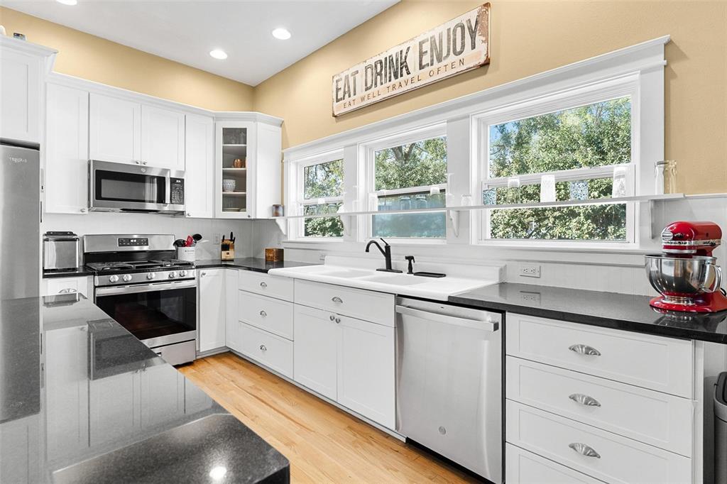 10616 Poe Street Leesburg, FL 34788 - Photo 19 of 54 a kitchen with stainless steel appliances white cabinets a sink and a stove