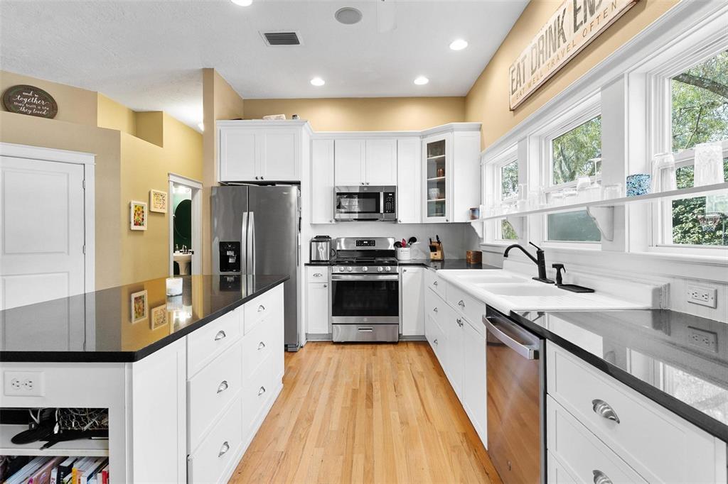 10616 Poe Street Leesburg, FL 34788 - Photo 20 of 54 a large kitchen with stainless steel appliances granite countertop a stove a sink and a refrigerator