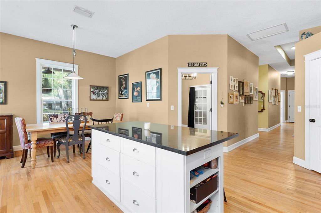 10616 Poe Street Leesburg, FL 34788 - Photo 22 of 54 a dining hall with stainless steel appliances granite countertop a dishwasher kitchen island a dining table and chairs with wooden floor
