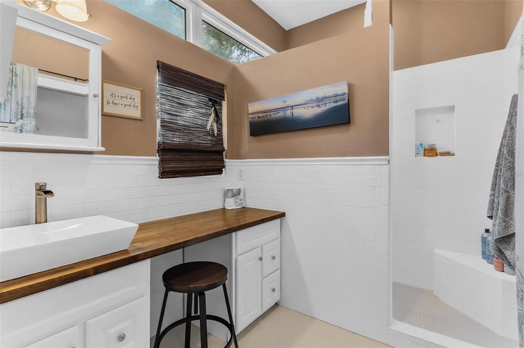 10616 Poe Street Leesburg, FL 34788 - Photo 36 of 54 a bathroom with a granite countertop sink a mirror and a bathtub