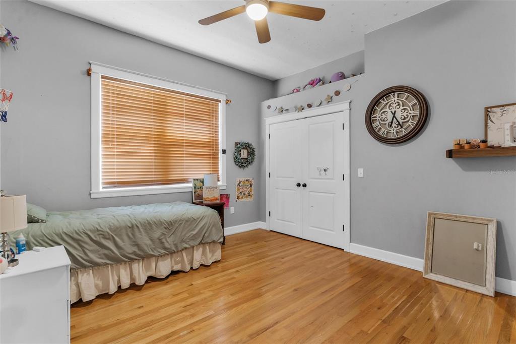 10616 Poe Street Leesburg, FL 34788 - Photo 41 of 54 a spacious bedroom with a bed and a clock on the dresser