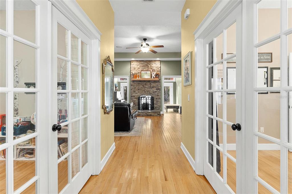 10616 Poe Street Leesburg, FL 34788 - Photo 10 of 54 a view of a hallway with wooden floor and a living room