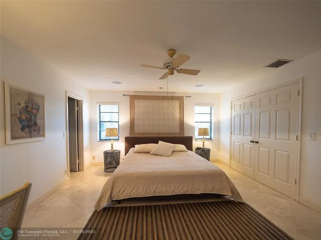 a bedroom with a large bed a lamp and a window