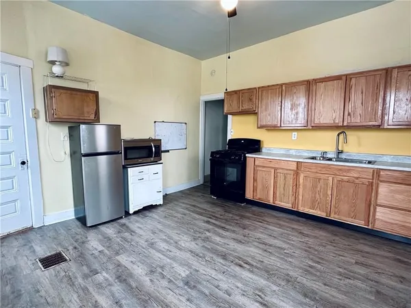 a kitchen with stainless steel appliances granite countertop a refrigerator a stove top oven a sink and dishwasher