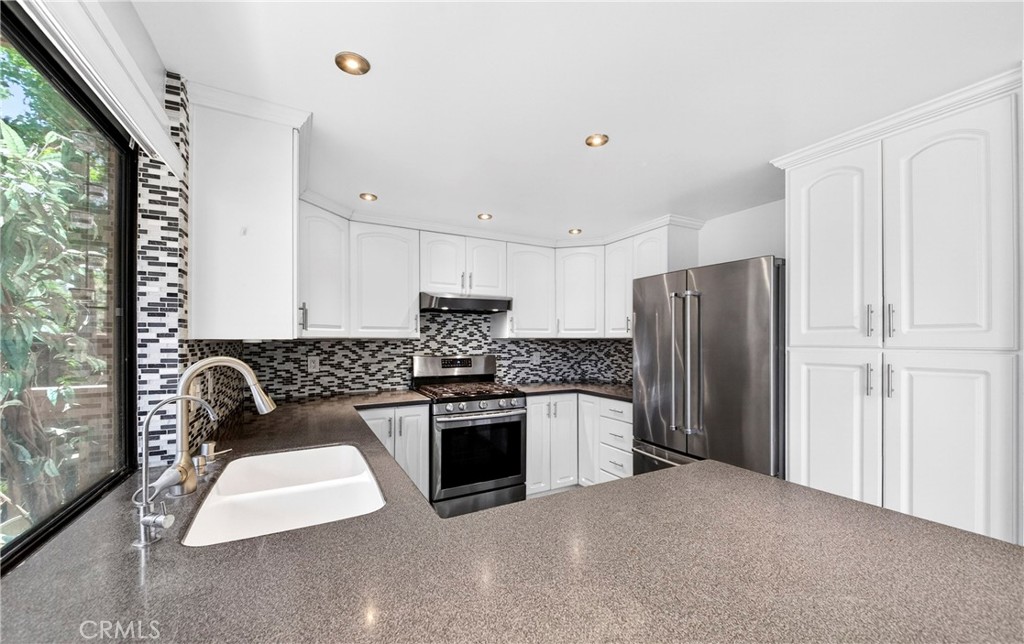 9 Madrona Irvine, CA 92612 - Photo 12 of 38 a kitchen with stainless steel appliances granite countertop a stove a refrigerator and a granite counter top